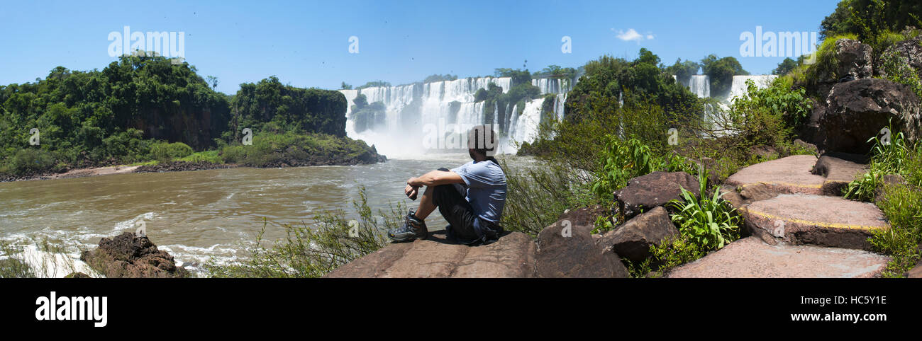 Iguazu: un uomo guardando le Cascate di Iguassù, generato dal fiume Iguazu, una delle più importanti attrazioni turistiche di America Latina Foto Stock