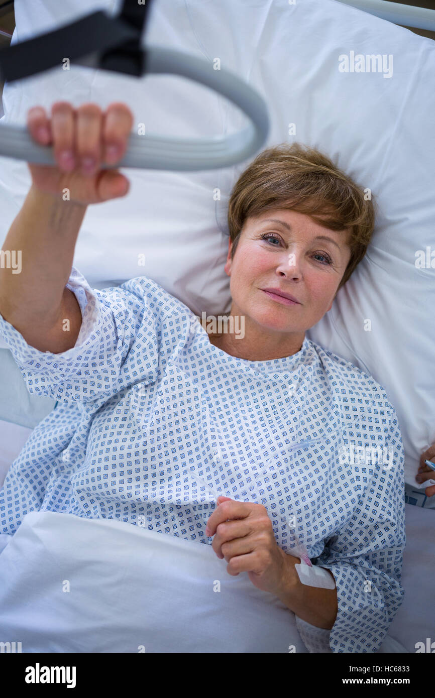 Ritratto di sorridere paziente sdraiato sul letto Foto Stock