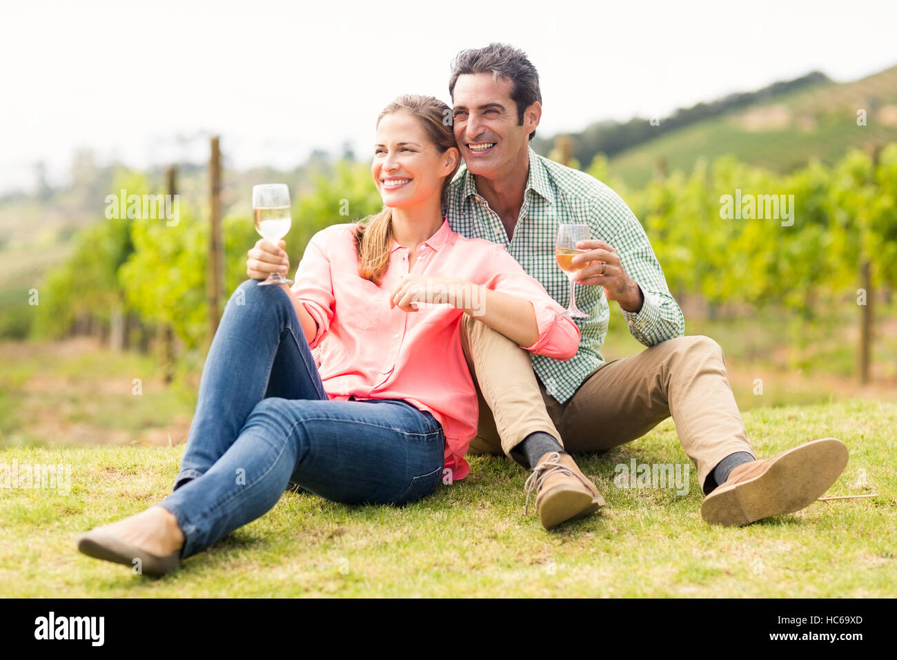 Coppia felice azienda bicchieri di vino e guardando la natura Foto Stock