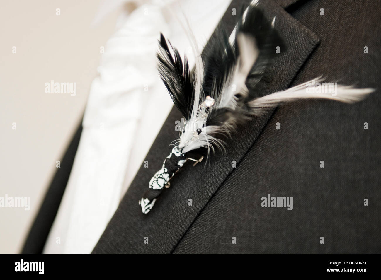 Lo sposo della puntina di incisione decorativa con dettaglio in piuma per un bianco e nero matrimonio a tema Foto Stock