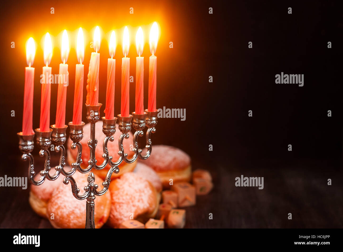 Simboli della festa ebraica hanukkah - menorah, ciambelle e sufganiyot dreidels Foto Stock