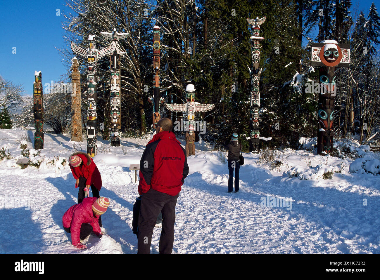 Stanley Park Totem al punto Brockton, Vancouver, BC, British Columbia, Canada - i turisti in visita in inverno Foto Stock