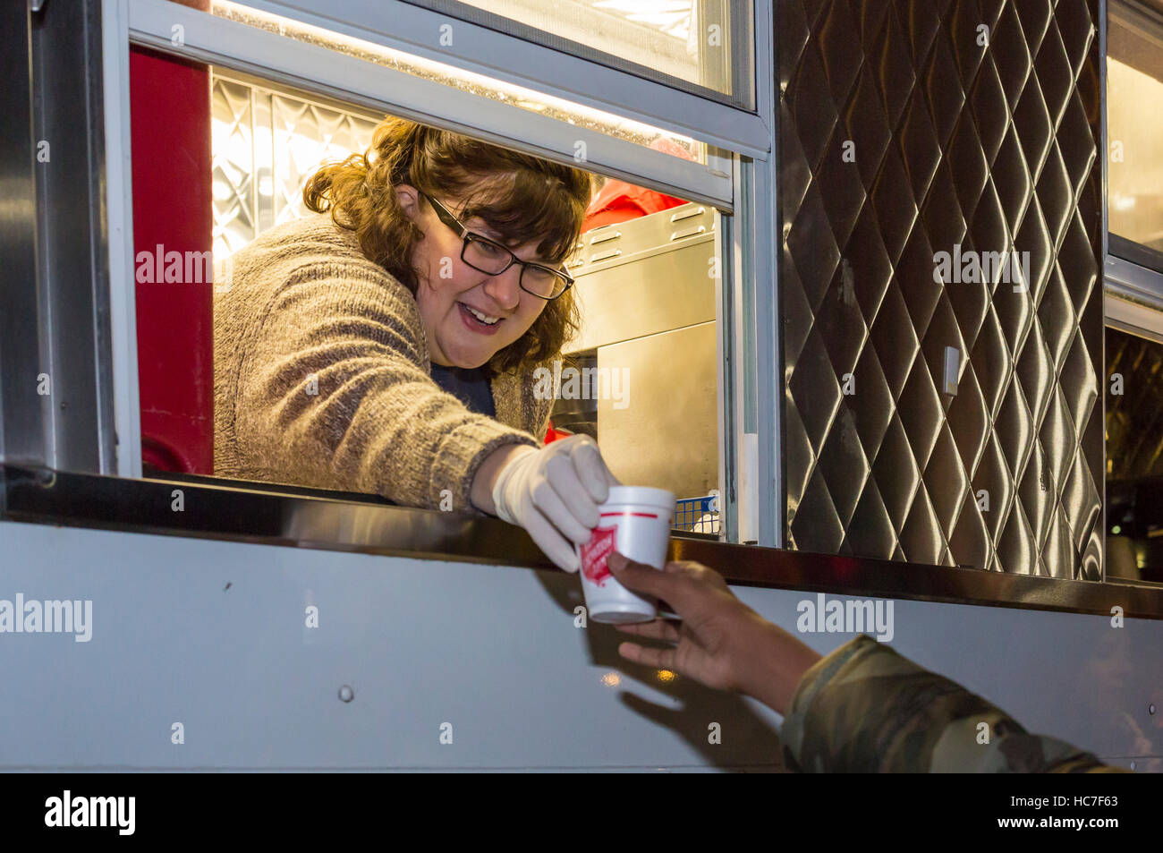 Detroit, Michigan - una donna in un Esercito della Salvezza carrello dà una cioccolata calda per le persone che frequentano Noel celebrazioni di notte. Foto Stock