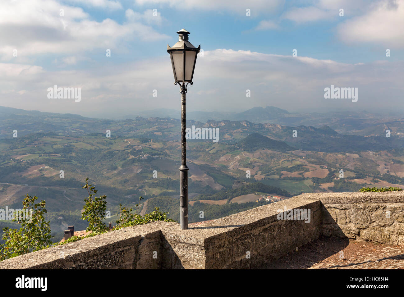 Lanterna sul vecchio marciapiede street a San Marino contro il cielo e il paesaggio vista da sopra. Foto Stock