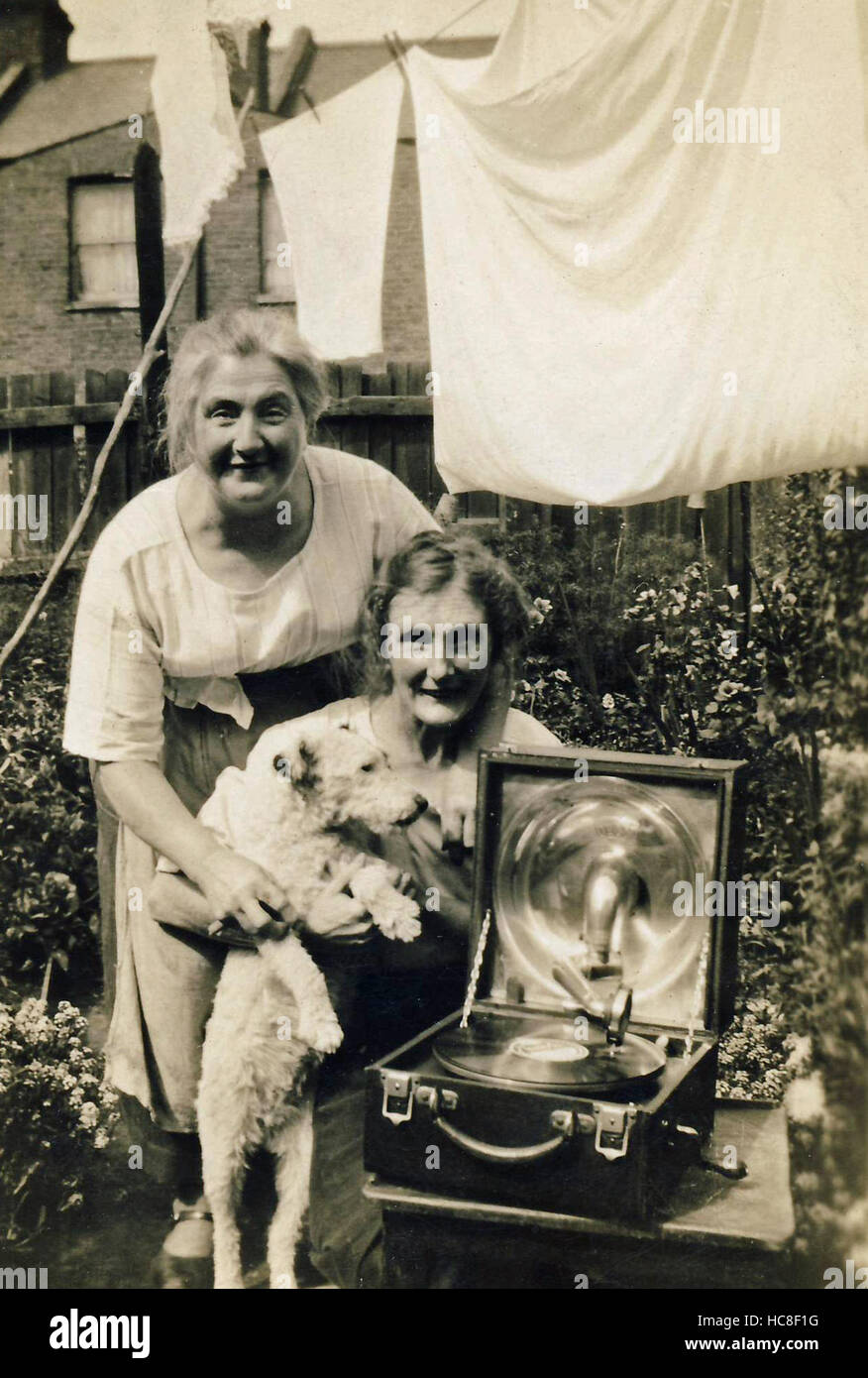 Archivio Storico di immagine delle donne nel giardino sul retro con il grammofono / record giocatore, e cane Foto Stock