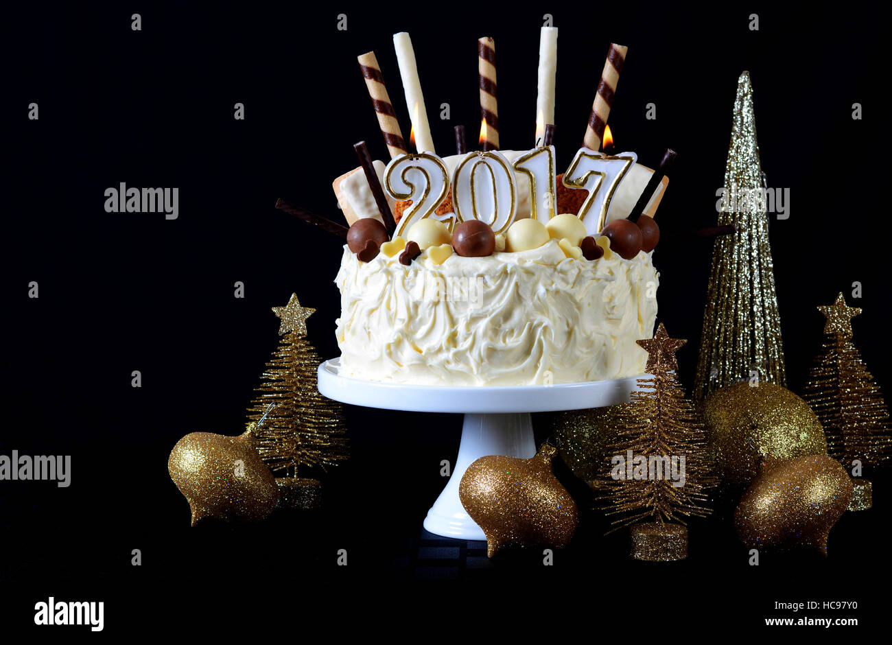 Periodo festivo 2017 Felice Anno Nuovo impediva di procedere centrotavola bianco torta al cioccolato con caramelle e biscotti decorazioni contro uno sfondo nero. Foto Stock