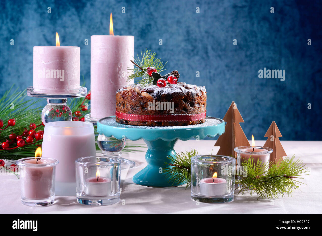 Per le feste con tavolo in stile inglese natale torta alla frutta con  glamour messa in tavola con candele rosa e blu, con copia spazio Foto stock  - Alamy