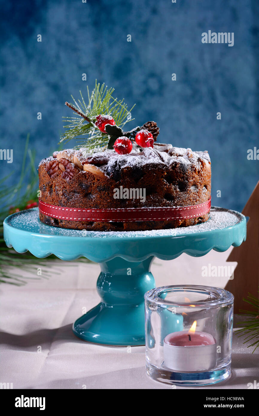 Per le feste con tavolo in stile inglese natale torta alla frutta con glamour messa in tavola con candele rosa e blu. Foto Stock