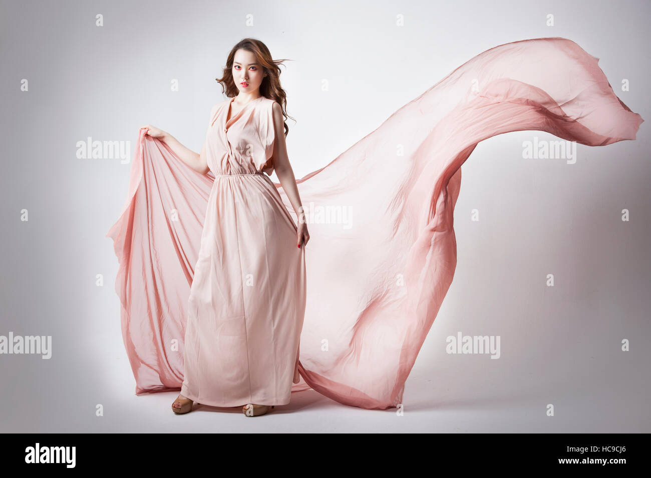 Giovane donna coreana in abito rosa in piedi Foto Stock