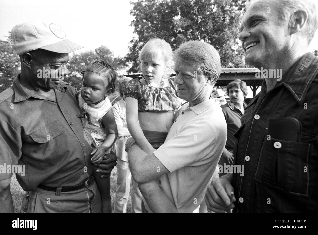 Astronauta e U.S. Il senatore da Ohio, John Glenn è intervistato per noi Vice Presidente nel 1976 da Jimmy Carter nelle pianure, GA. Qui, Carter, sua figlia Amy e Glenn soddisfare con carter di affittuario Leonard Wright e sua figlia toddler sulla famiglia terreni agricoli al di fuori delle pianure, GA. Foto Stock