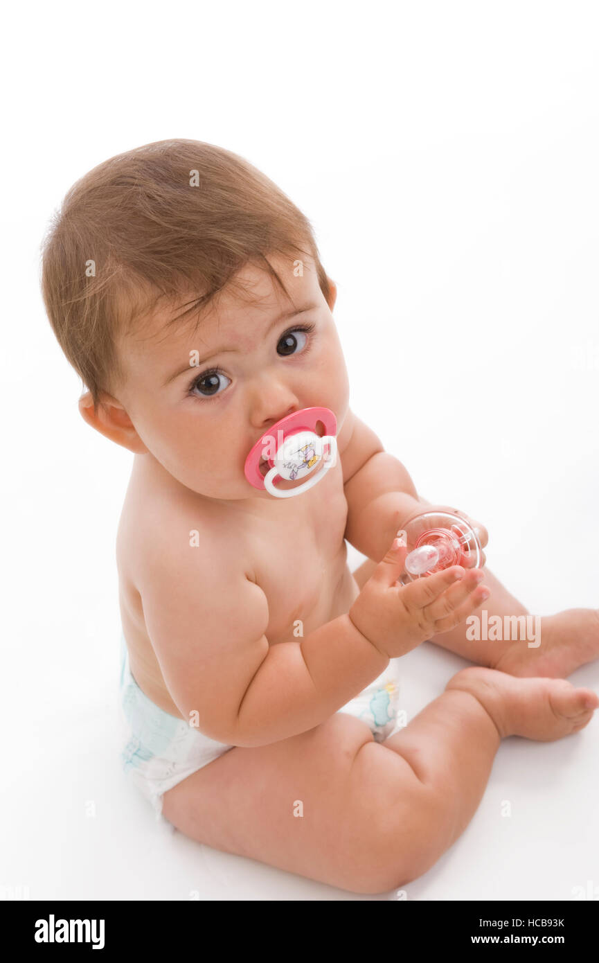 Un giovane bambino, 8 mesi, con fantoccio e il pannolino Foto Stock