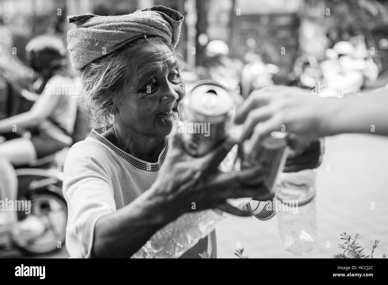 Povera donna indonesiana che raccoglie bottiglie vuote e lattine di birra Foto Stock