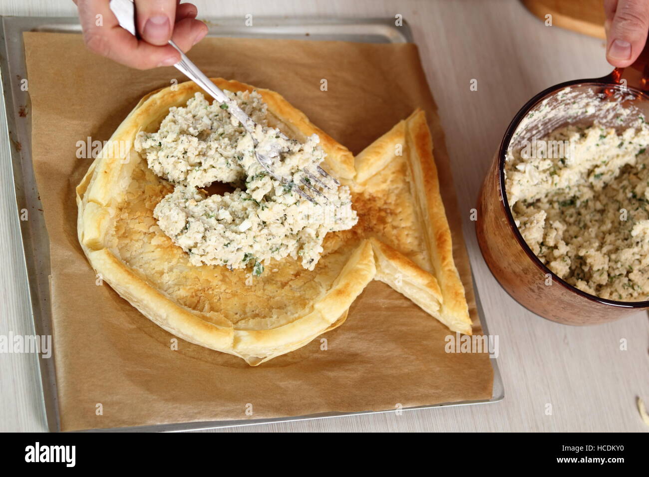 Posizionare il riempimento sulla pasta preparata. Rendendo il salmone in pasta sfoglia serie. Foto Stock