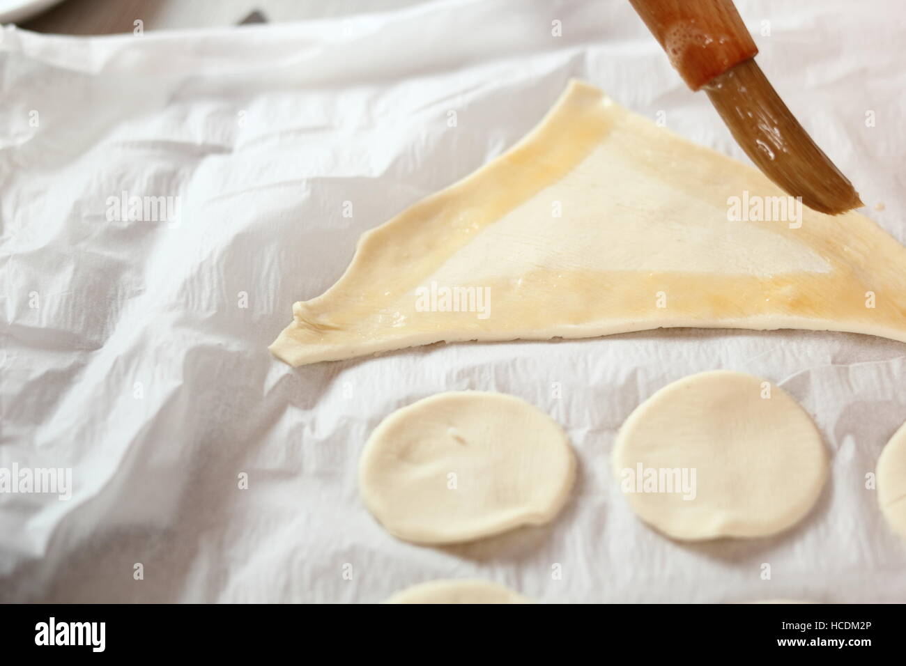 Spennellare con uovo smalto forma di coda della pasta sfoglia pezzi. Rendendo il salmone in pasta sfoglia serie. Foto Stock