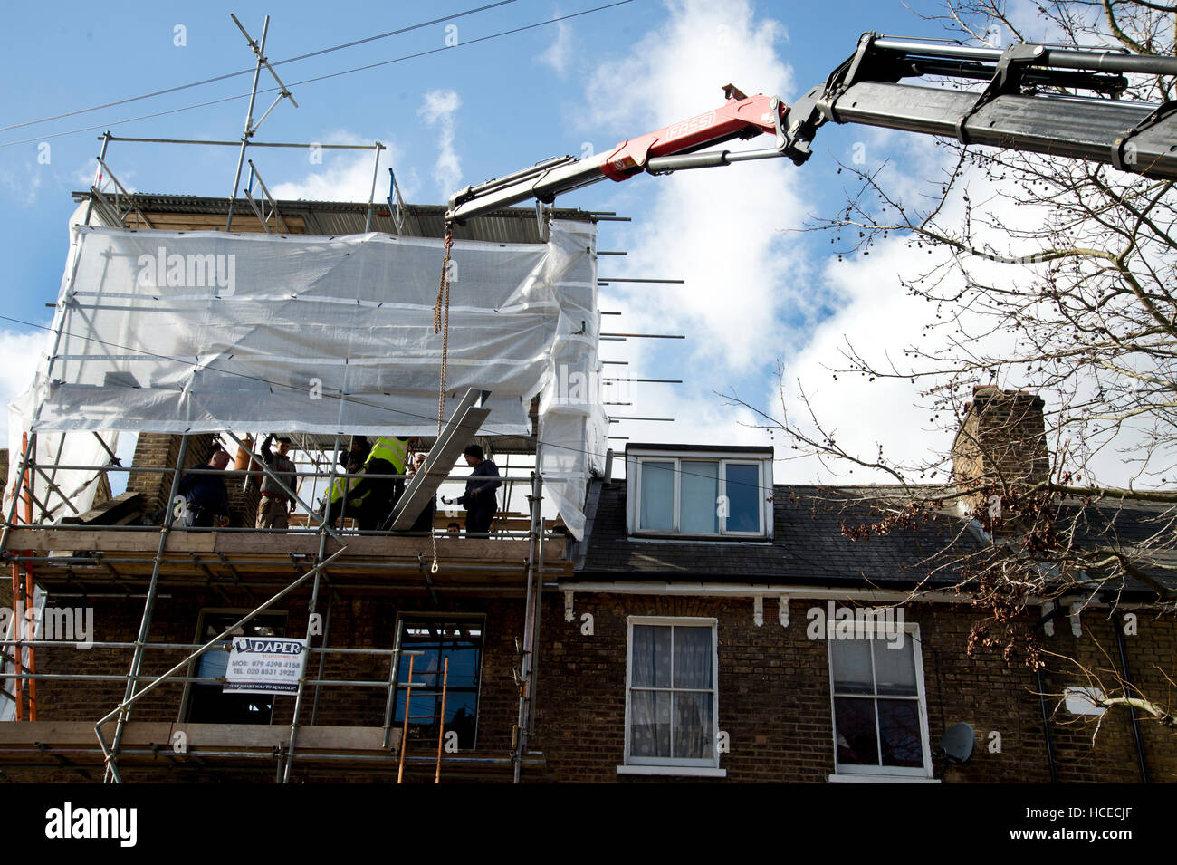 Hackney. Gentrification. Facendo fino a casa - mettendo su un nuovo tetto. Foto Stock