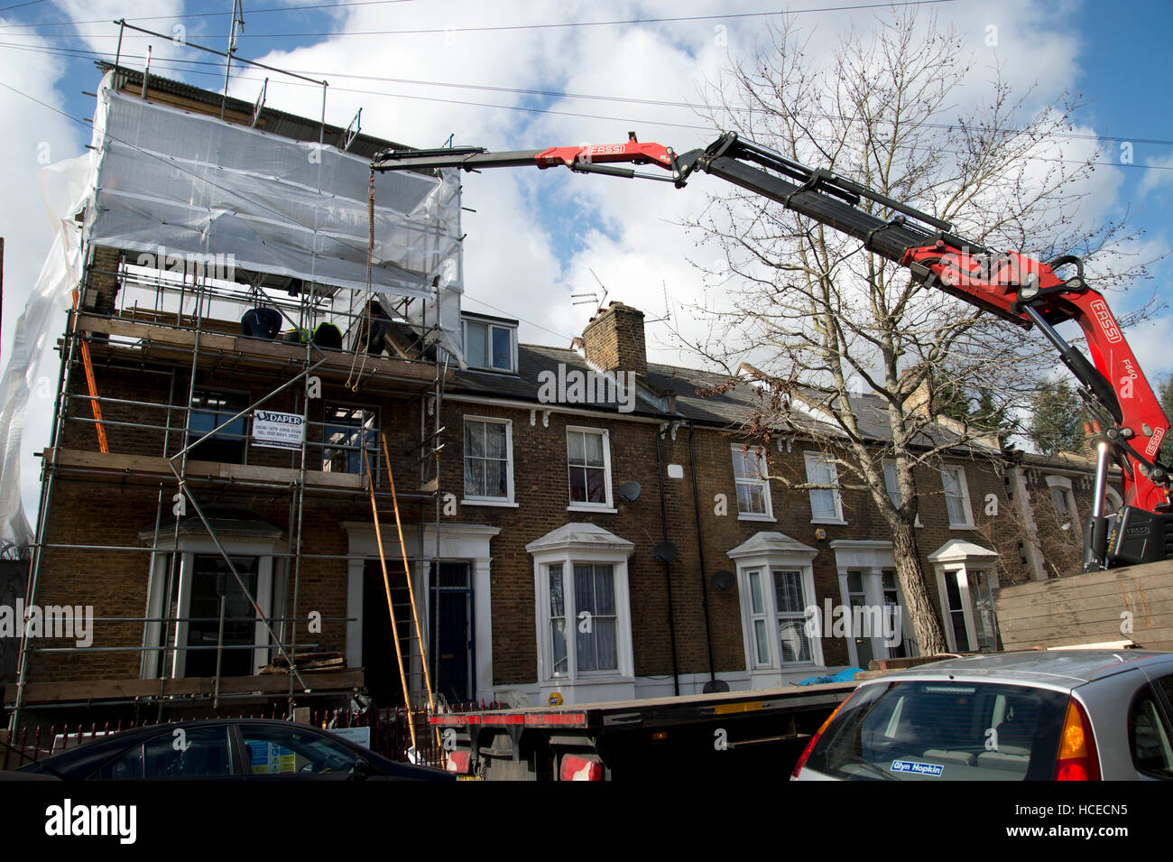 Hackney. Gentrification. Facendo fino a casa - mettendo su un nuovo tetto. Foto Stock