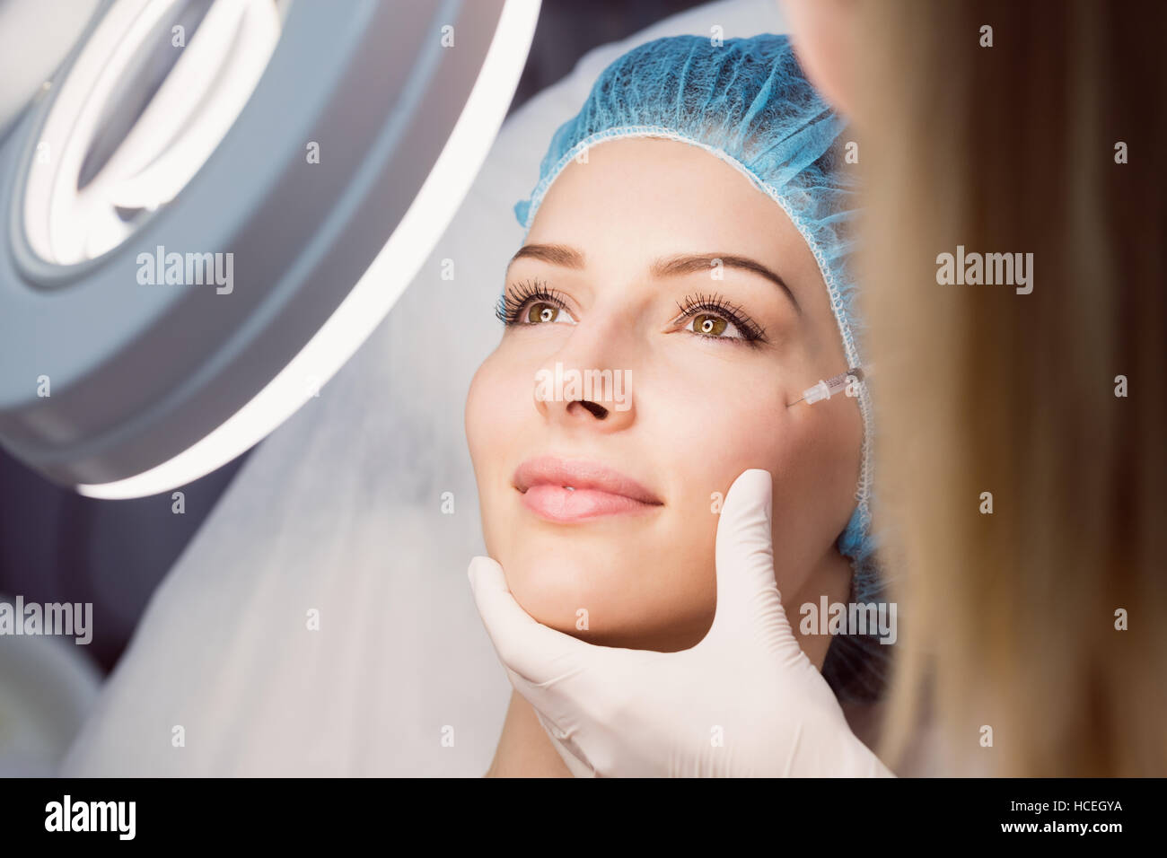 Giovane donna la ricezione di botox iniezione sul suo viso Foto Stock