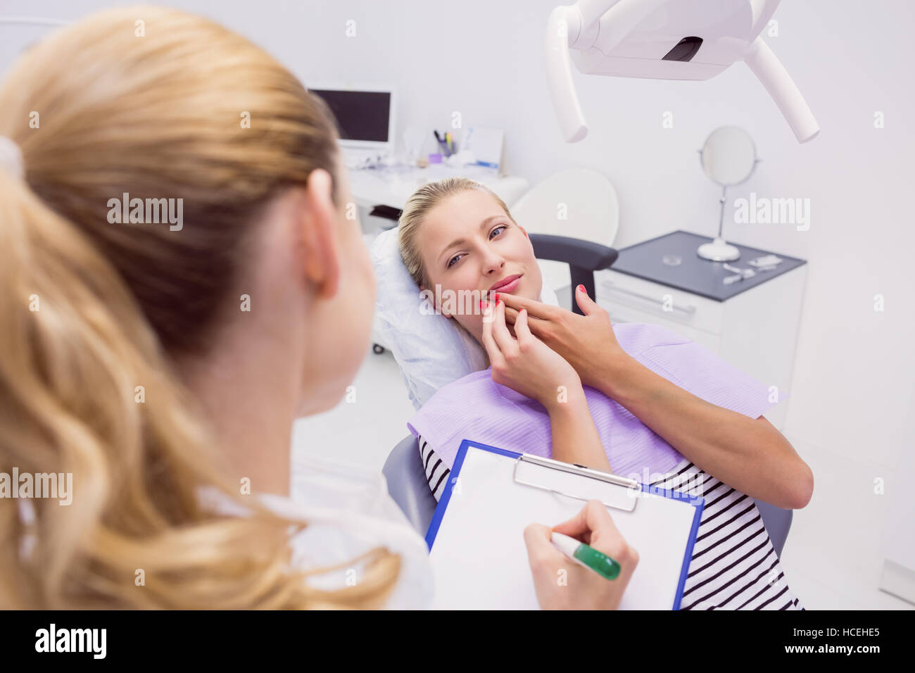 Paziente di sesso femminile con il mal di denti in clinica Foto Stock