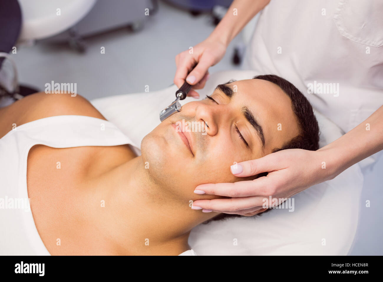 Il dermatologo di eseguire la depilazione laser su paziente Foto Stock