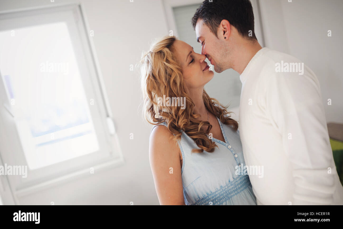 Il marito baciare bionda moglie a casa Foto Stock