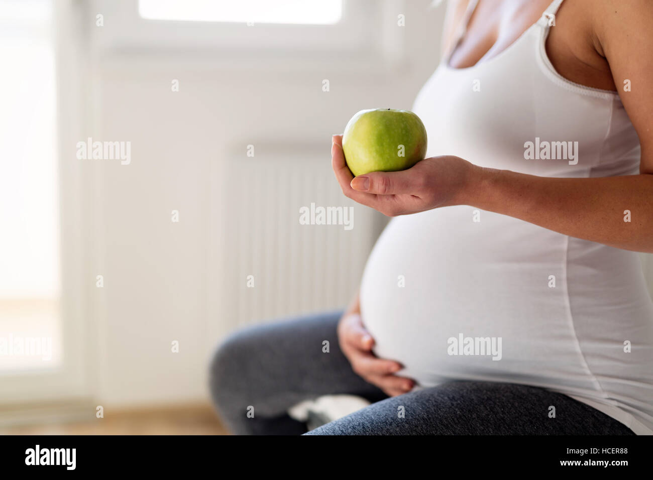 Un sano donna incinta mangiare ricco di vitamina apple Foto Stock