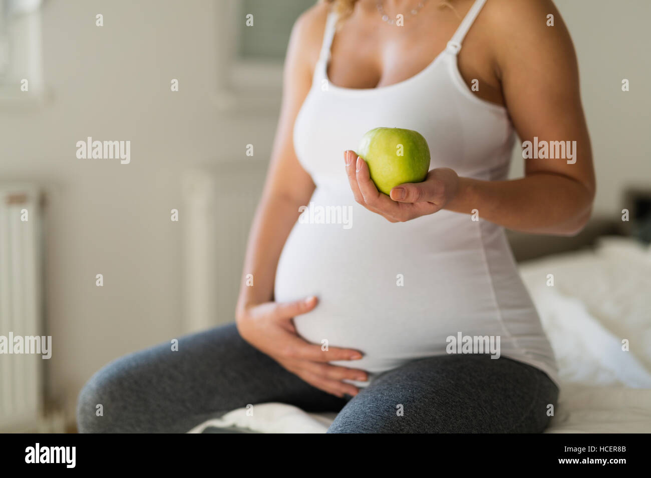 Un sano donna incinta mangiare ricco di vitamina apple Foto Stock