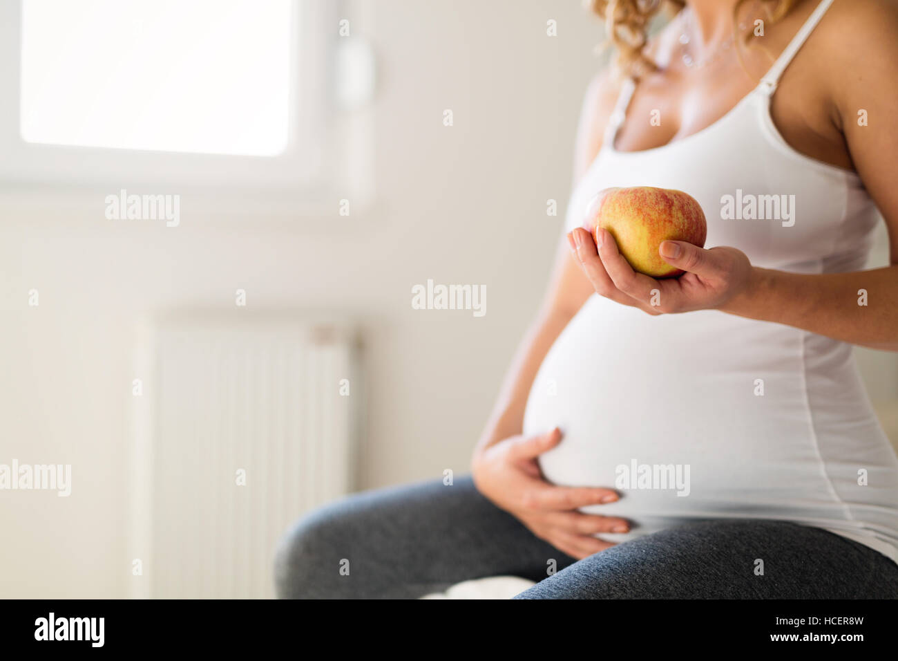 Un sano donna incinta mangiare ricco di vitamina apple Foto Stock