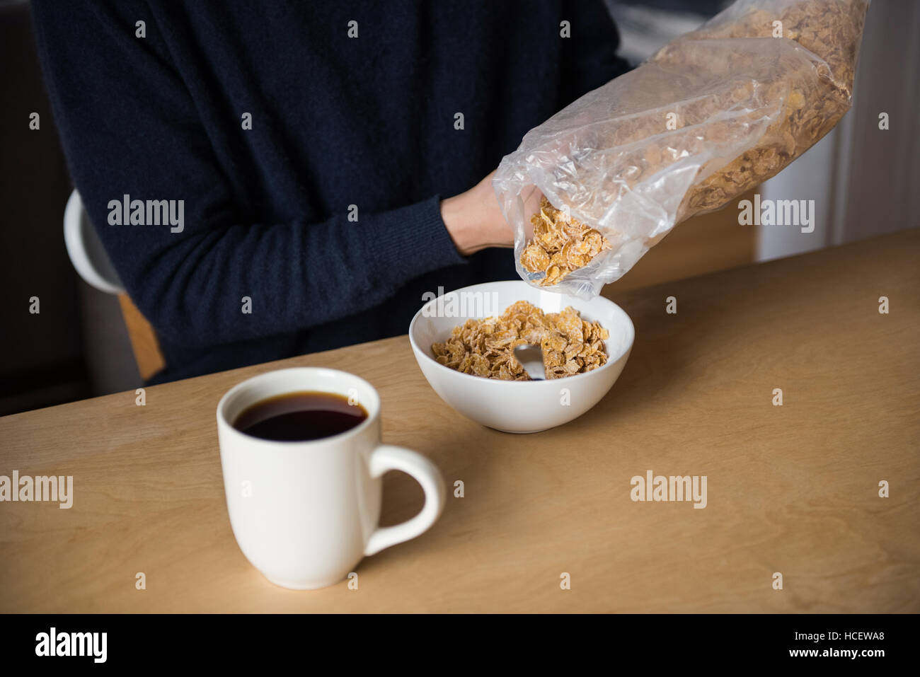 Sezione intermedia dell'uomo versando i cereali nel recipiente Foto Stock