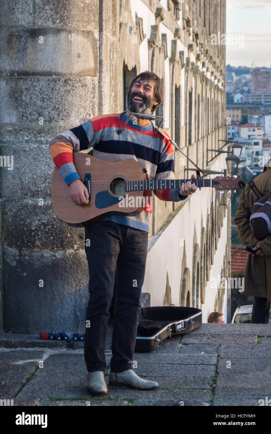 Un suonatore ambulante di suonare una chitarra, Terreiro do Sé, Porto, Portogallo Foto Stock