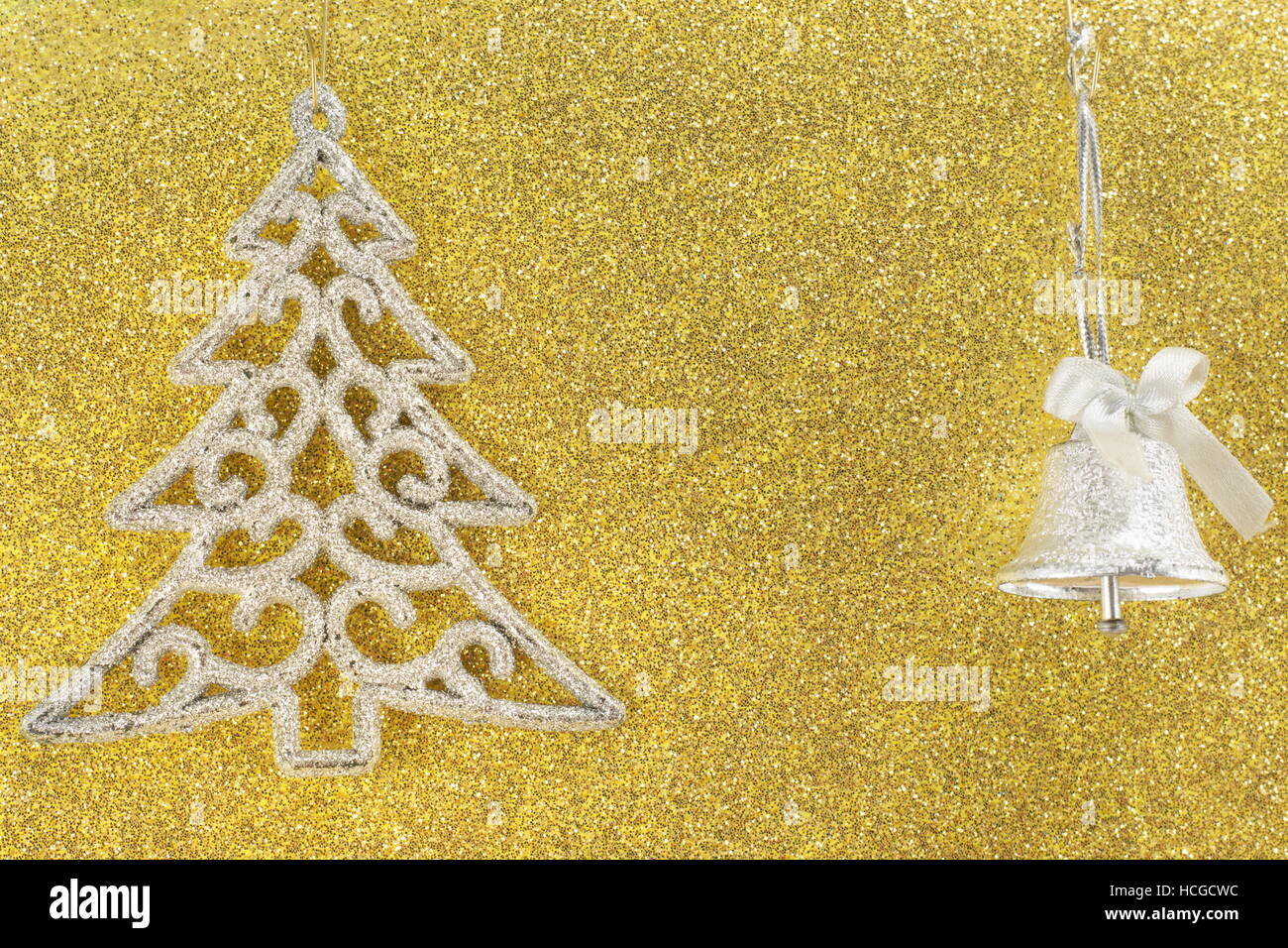 Argento albero di natale ornamento su sfondo dorato con una campana di natale Foto Stock