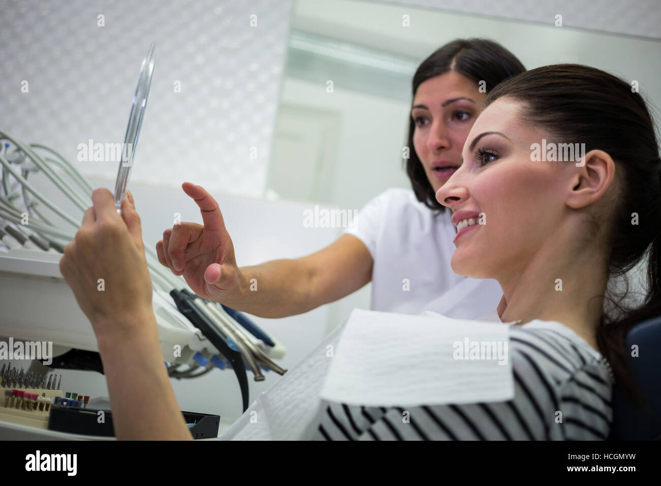 Paziente controllando i suoi denti in specchio Foto Stock