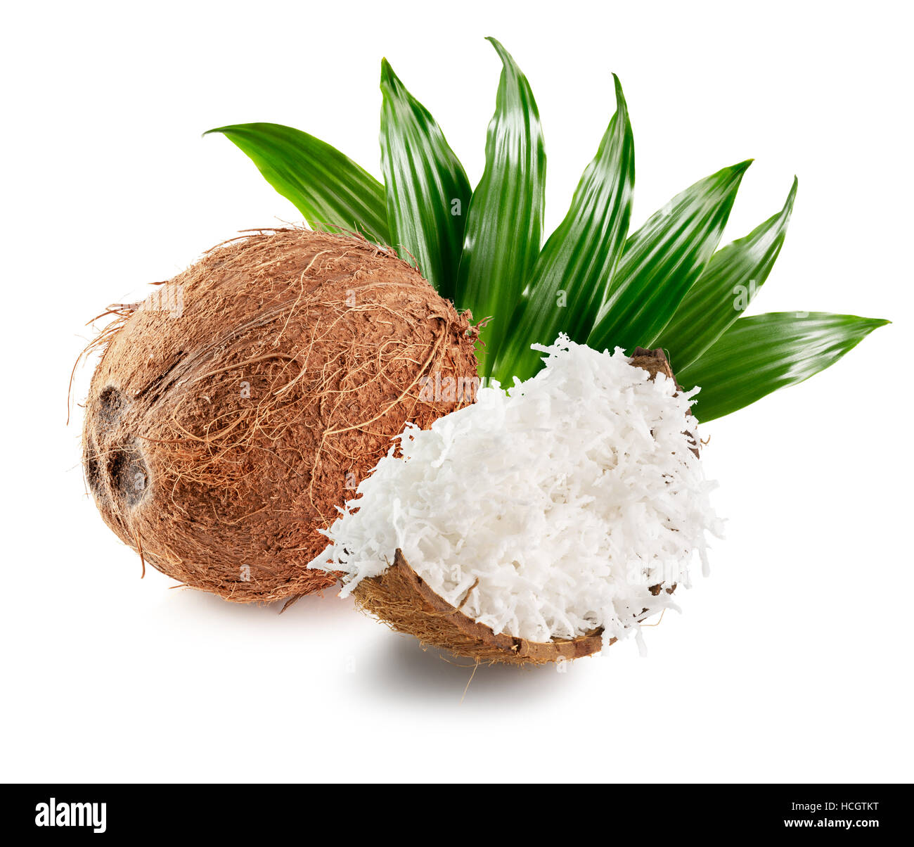 Noce di cocco con scaglie di noce di cocco e foglie isolate su uno sfondo bianco. Foto Stock
