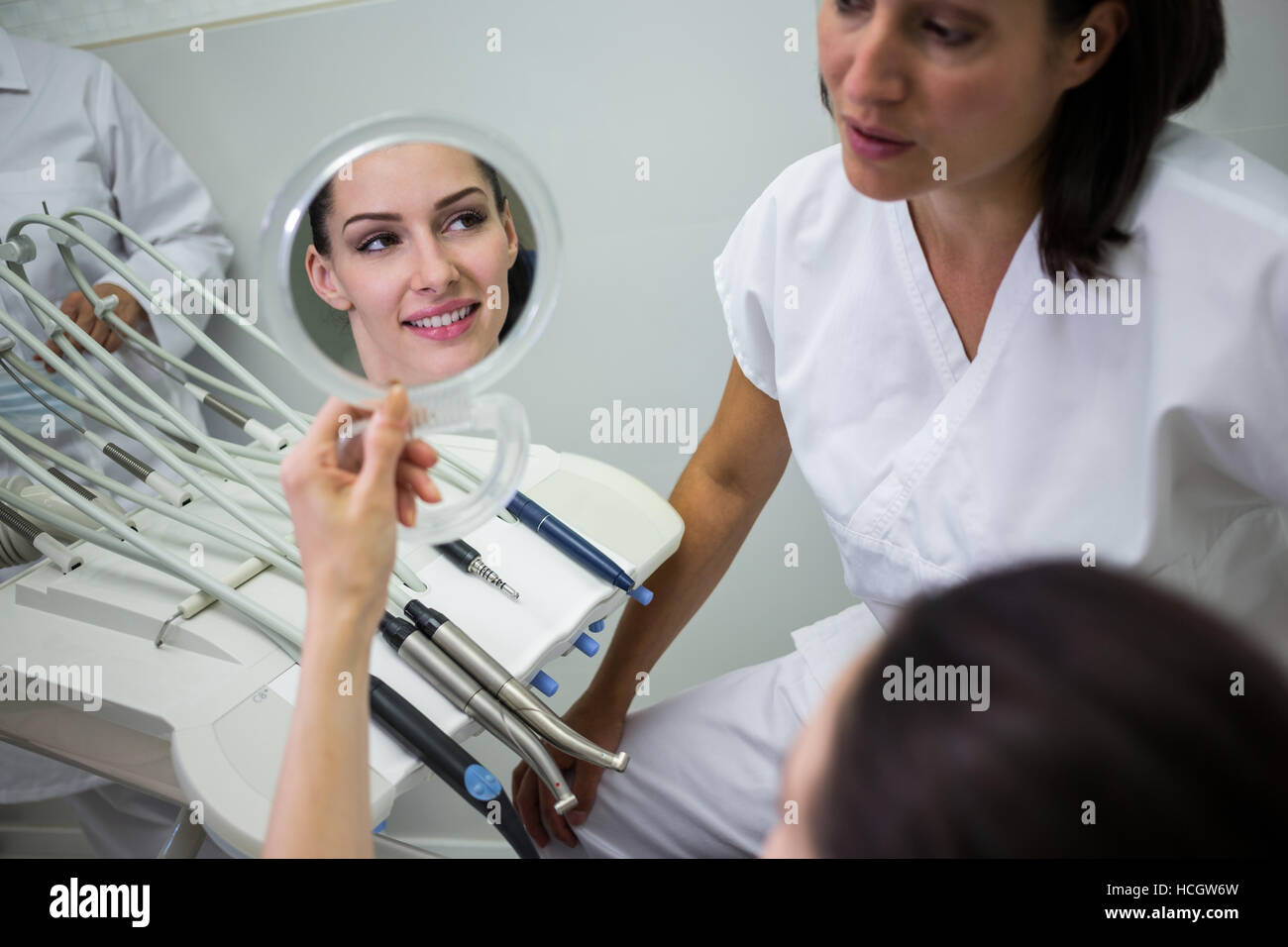 Paziente controllando i suoi denti in specchio Foto Stock