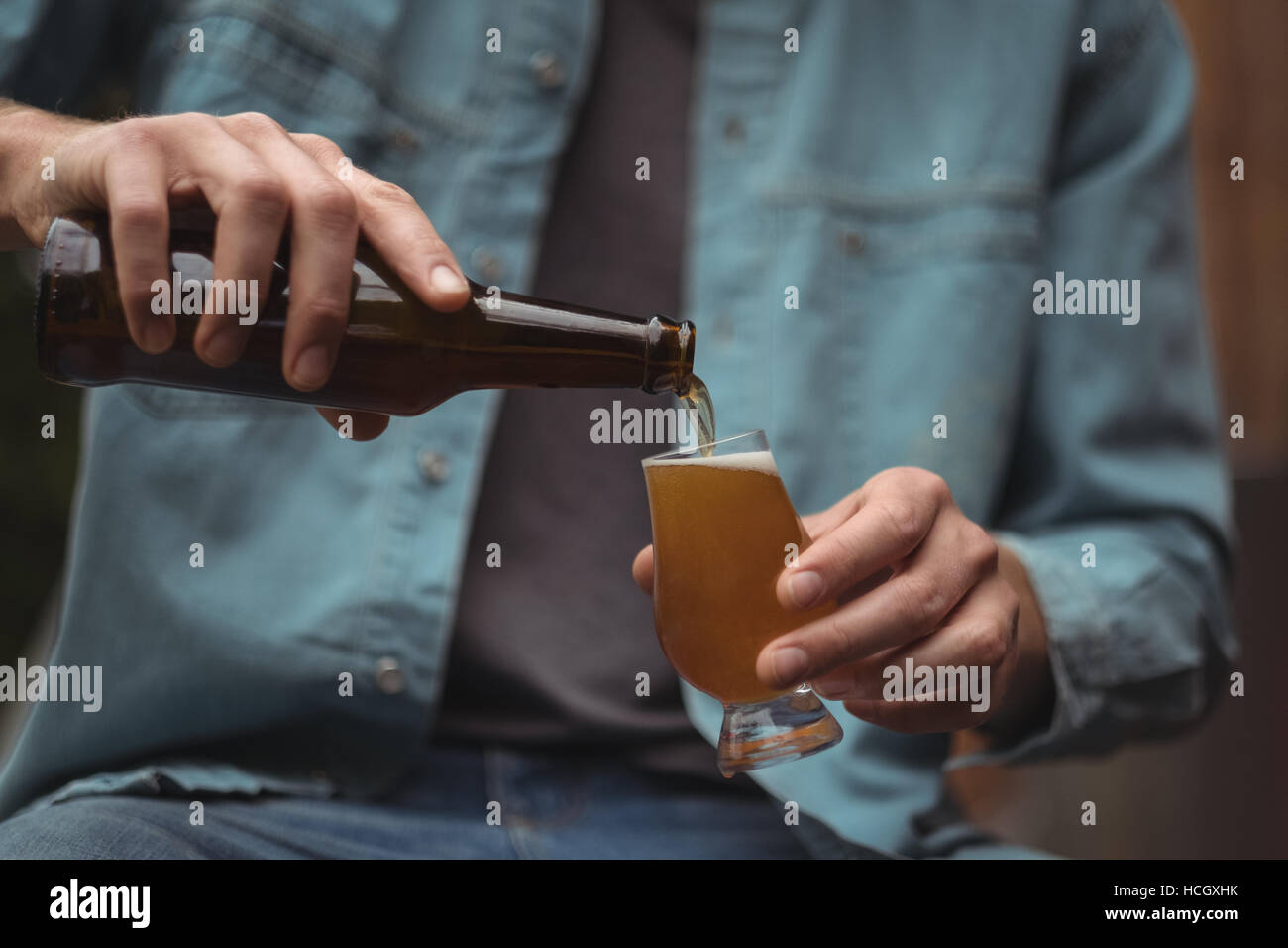 L uomo come spillare la birra in un bicchiere di birra Foto Stock