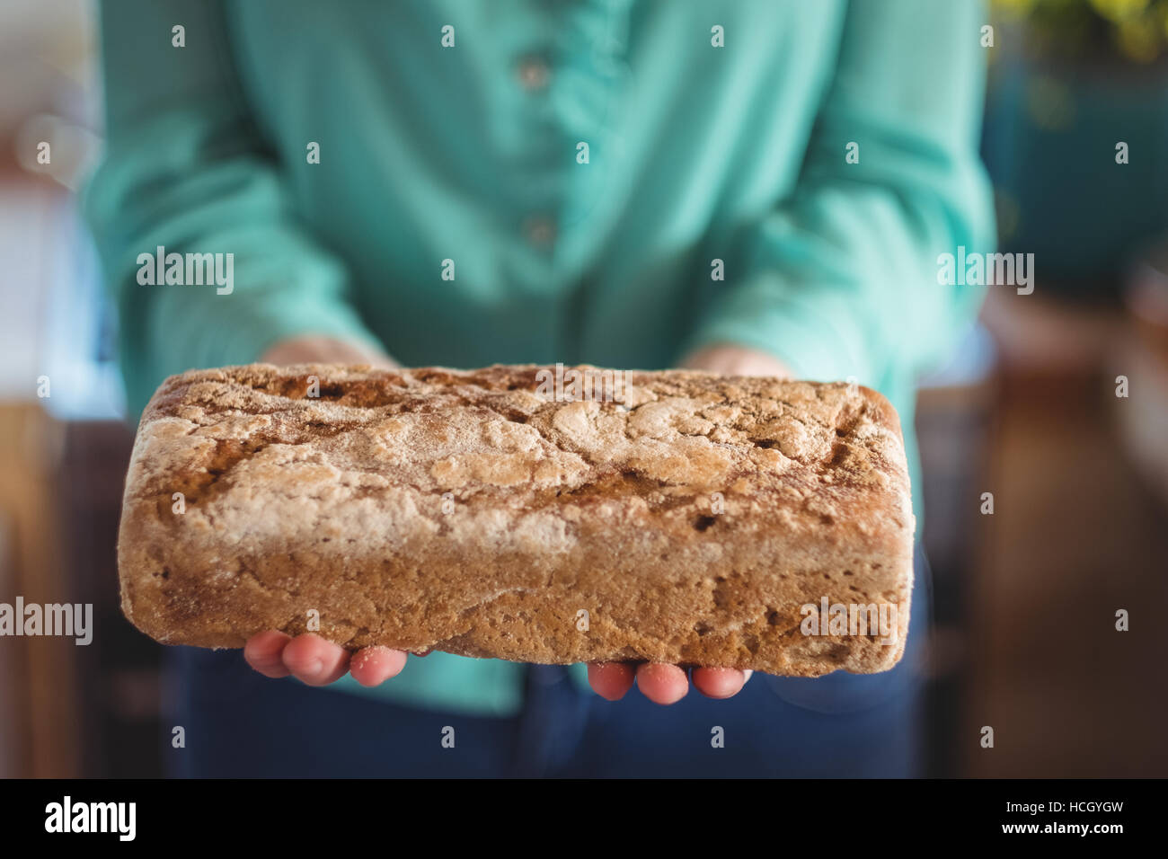 La sezione centrale della donna che mantiene il pane cotto al forno Foto Stock