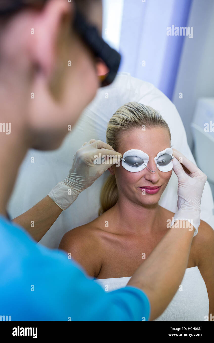 Il dermatologo regolazione degli occhiali di protezione Foto Stock