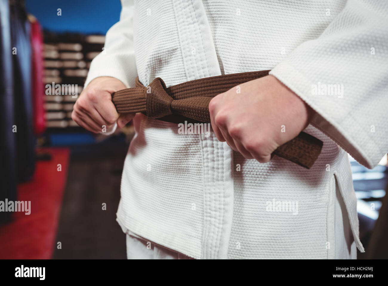 Lettore di Karate la legatura della sua cintura Foto Stock