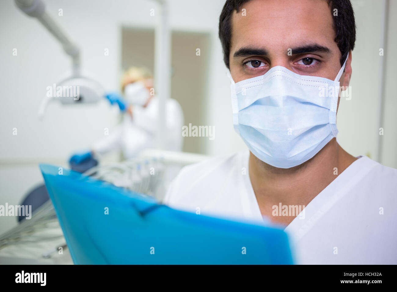 Dentista nella mascherina chirurgica in clinica dentale Foto Stock