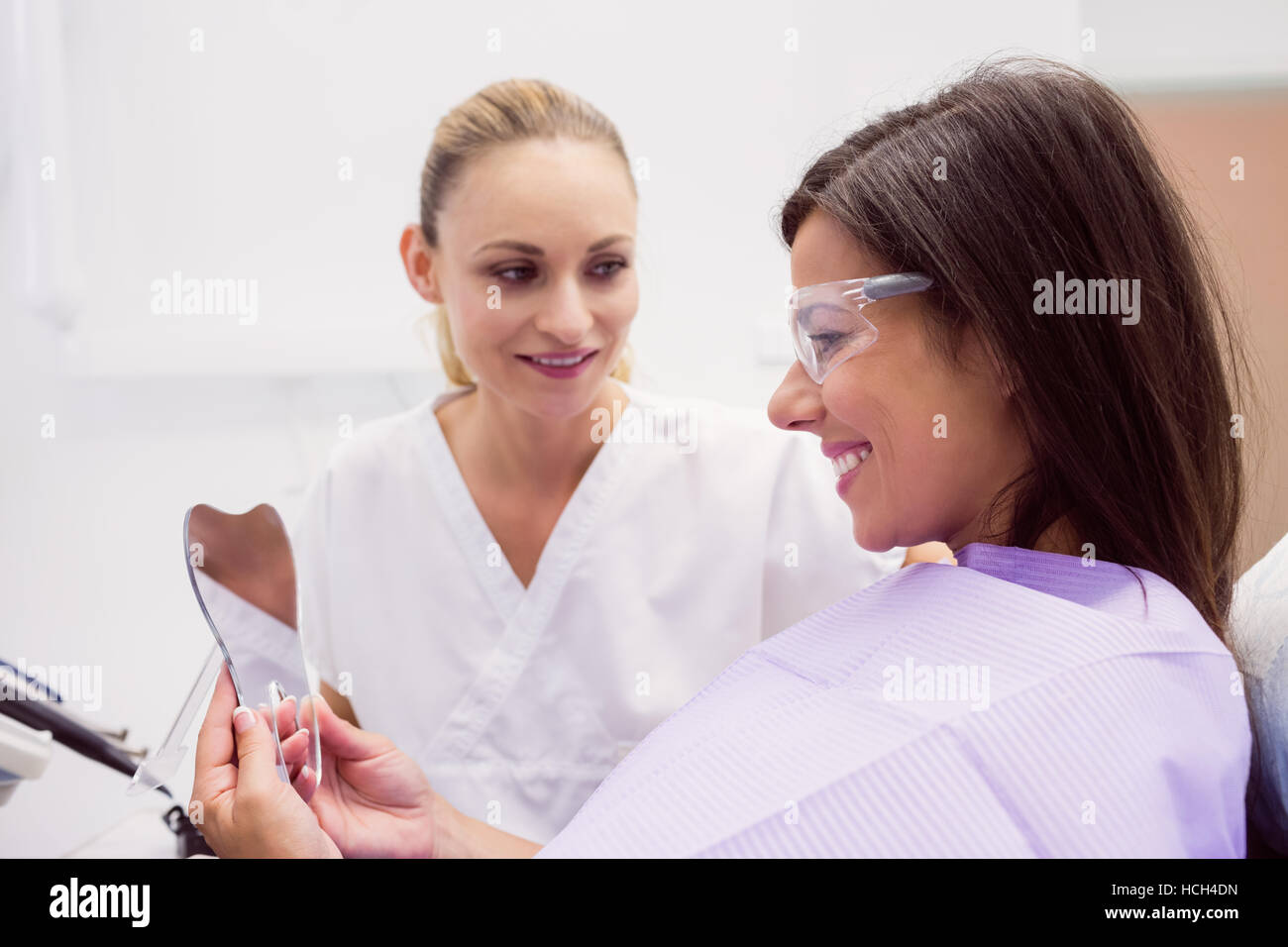 Paziente femmina di sorridere mentre guardando sullo specchio Foto Stock
