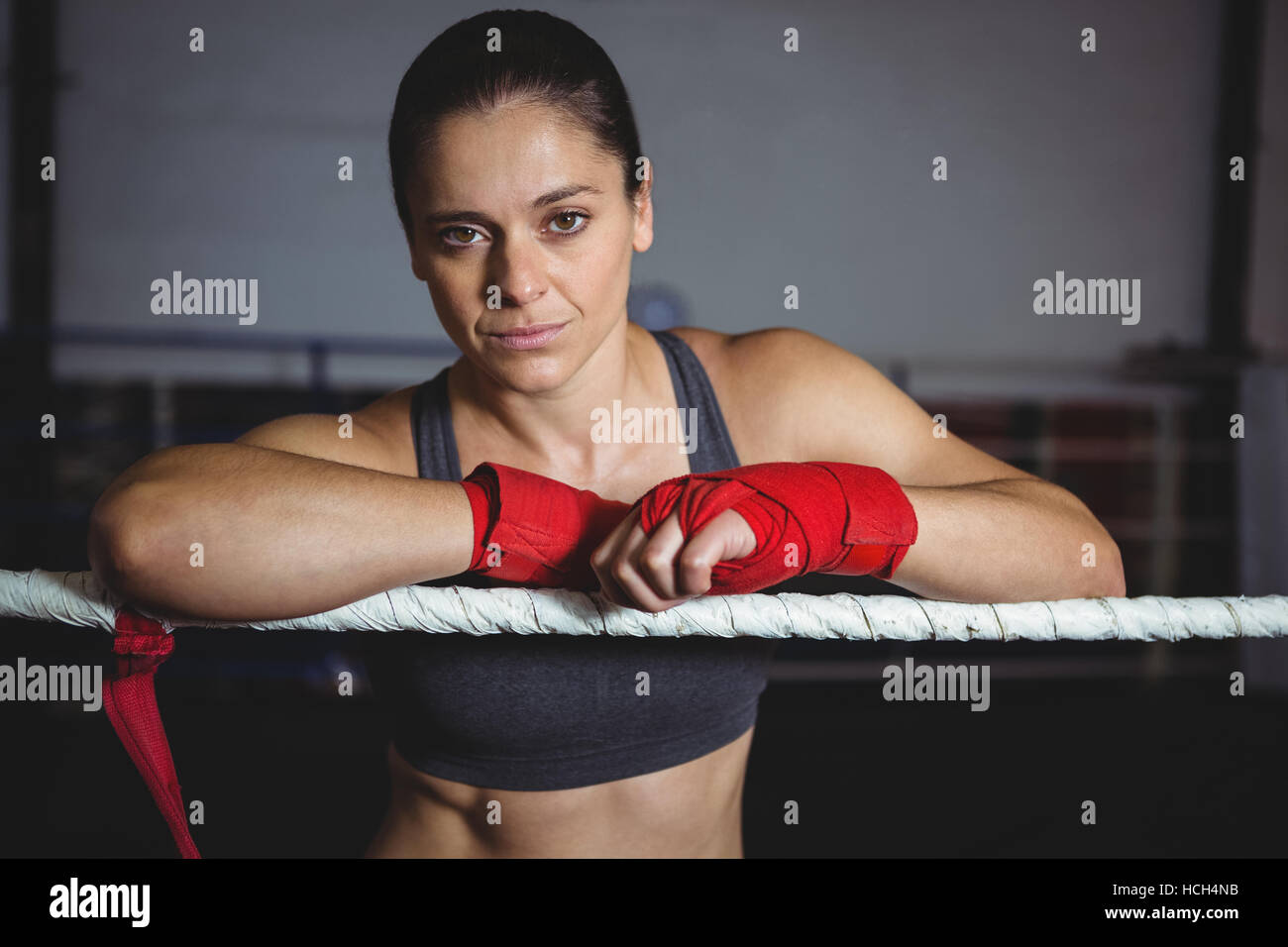 Fiducioso boxer femmina appoggiato su di pugilato ring Foto Stock