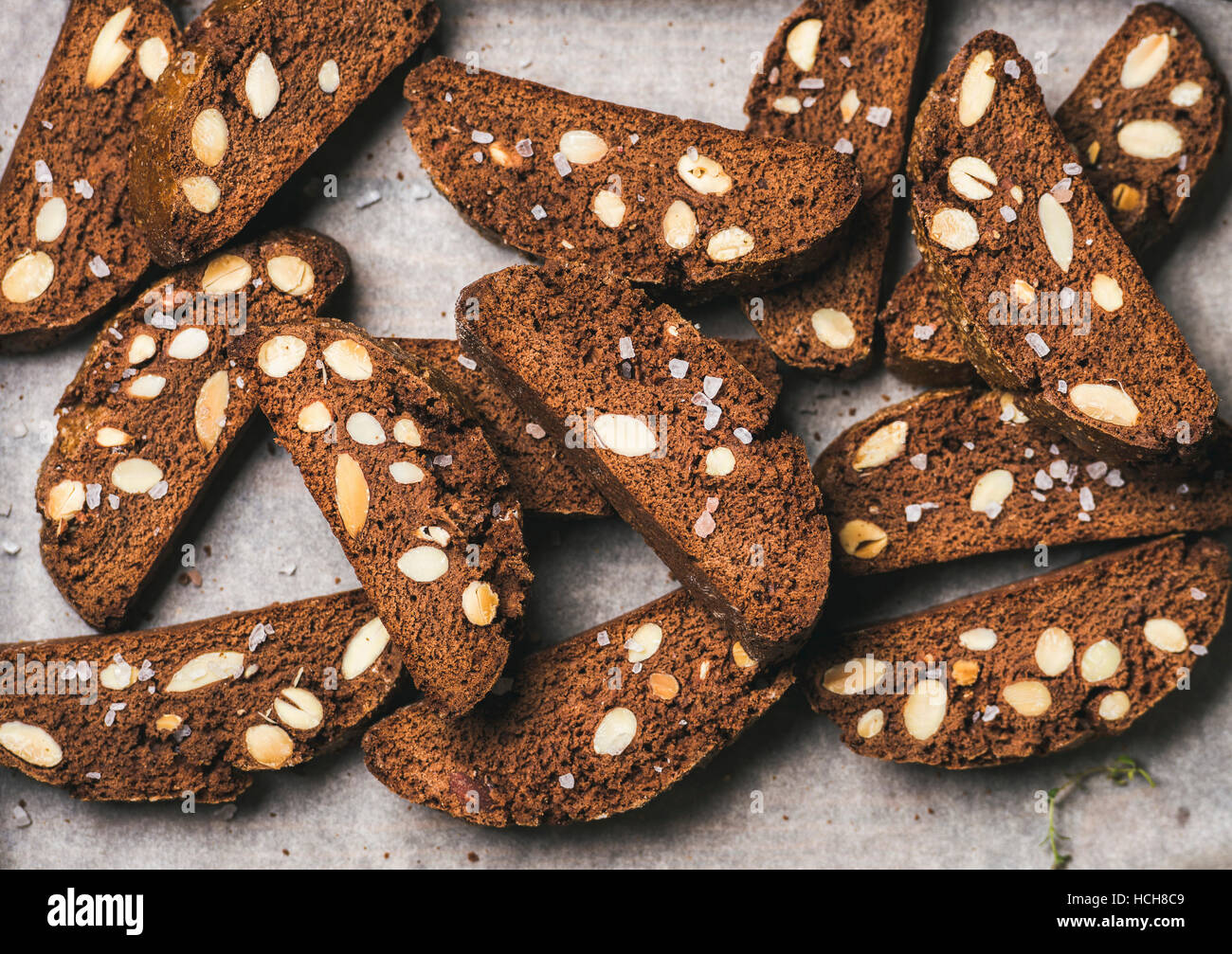 Close-up di cioccolato fondente e sale marino biscotti con le mandorle sulla carta da forno, vista dall'alto, composizione orizzontale Foto Stock