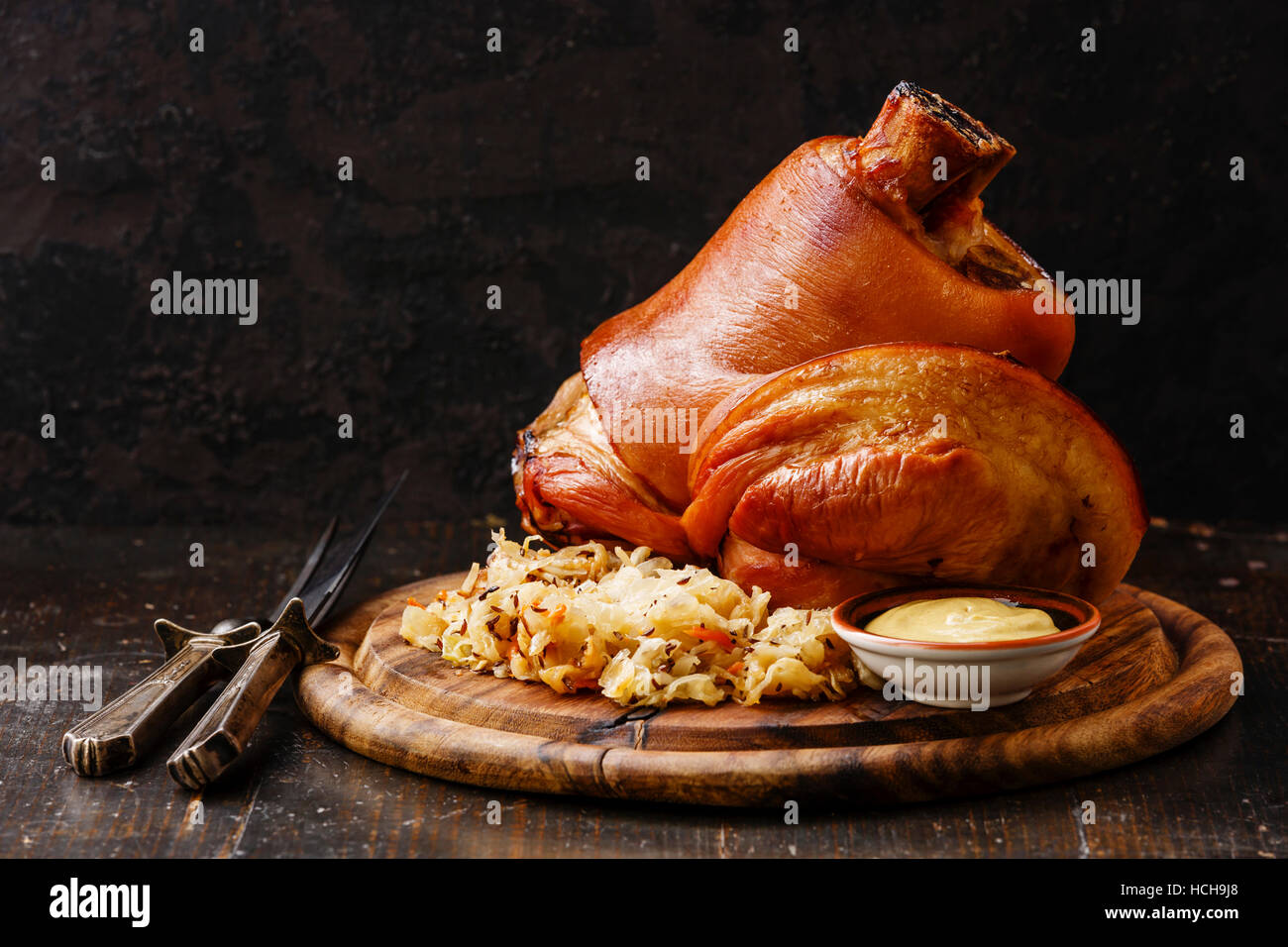 Arrosto di maiale eisbein fuso a snodo con brasato di Cavoli lessi e senape sul tagliere di legno Foto Stock