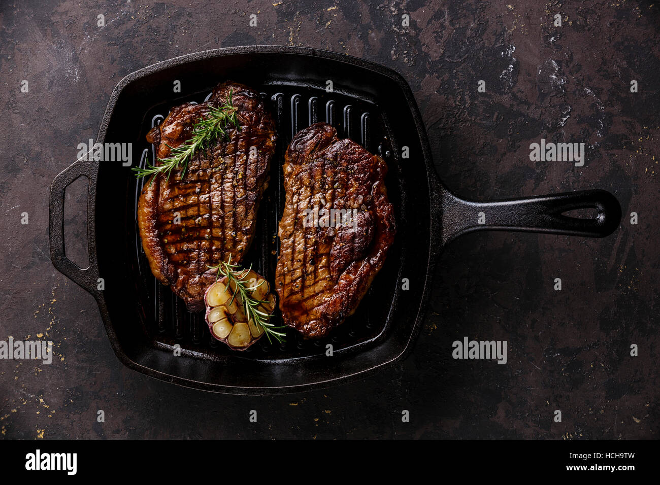 Grigliata di Black Angus Bistecca di controfiletto su frittura ghisa padella per grigliare su sfondo scuro Foto Stock