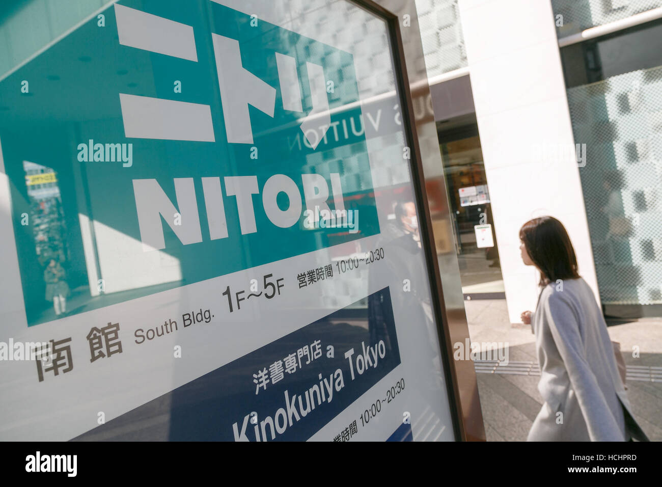 Una donna cammina passato Nitori un cartello sul display vicino al nuovo Nitori department store di Shinjuku's Takashimaya e Times Square il 9 dicembre 2016 a Tokyo, in Giappone. Nitori Holdings ha aperto il nuovo arredamento e home negozio di accessori in South Hall di Tokyo's Takashimaya e Times Square complesso commerciale su dicembre 1st. La società prevede di aumentare il numero dei suoi negozi a 2000 oltremare e 1000 in Giappone dal 2032. © Rodrigo Reyes Marin/AFLO/Alamy Live News Foto Stock