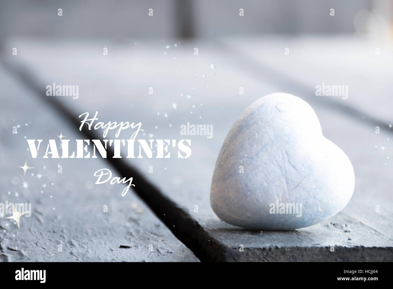 Cuore su un tavolo in legno e felice il giorno di San Valentino del testo Foto Stock