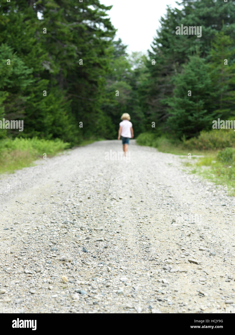 Ragazza cammina per strada di ghiaia sull isola di Maine Foto Stock