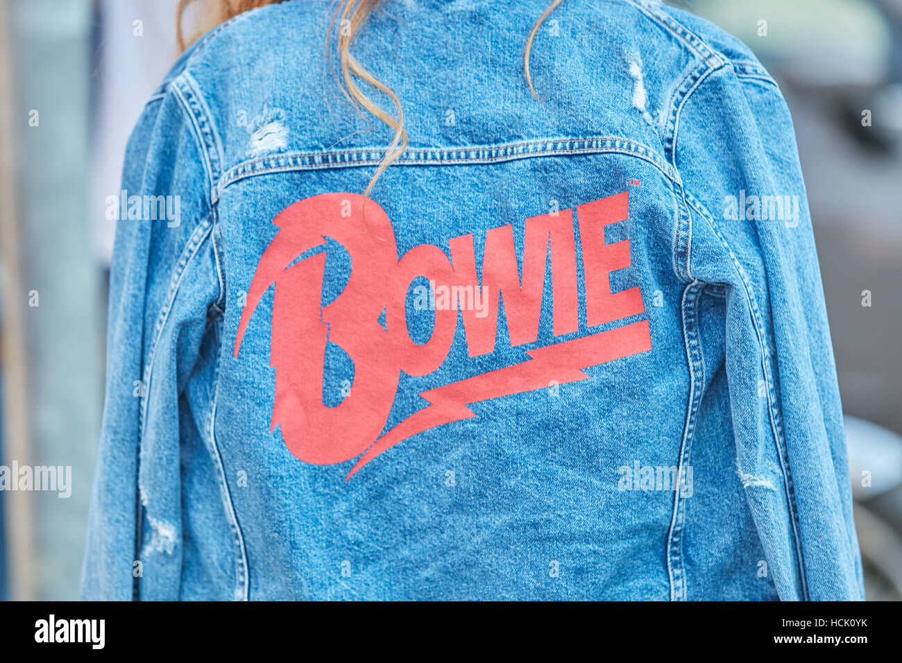 Donna con jeans blu giacca con red Bowie iscritto prima Jil Sander fashion show, la Settimana della Moda Milanese street style a settembre Foto Stock