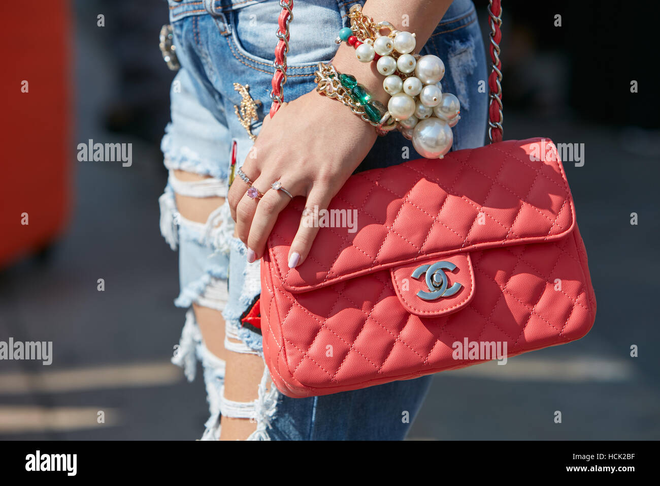 Donna con red Chanel bag e grandi perle bracciale prima Stella Jean fashion show, la Settimana della Moda Milanese street style in settembre. Foto Stock
