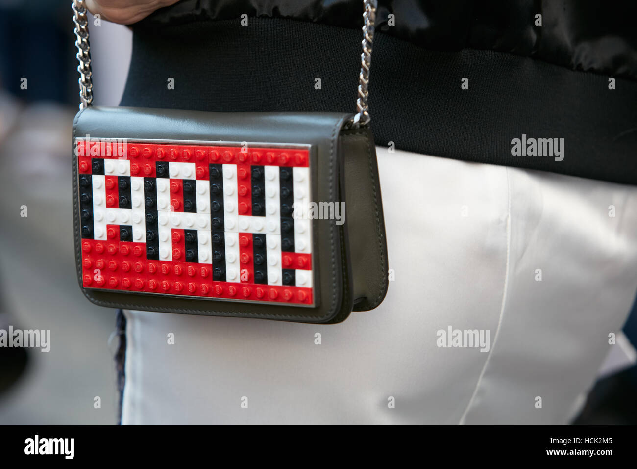 Donna con la borsa con il bianco e il rosso Lego iscritto Ah! Prima di Salvatore Ferragamo fashion show, la Settimana della Moda Milanese street style. Foto Stock
