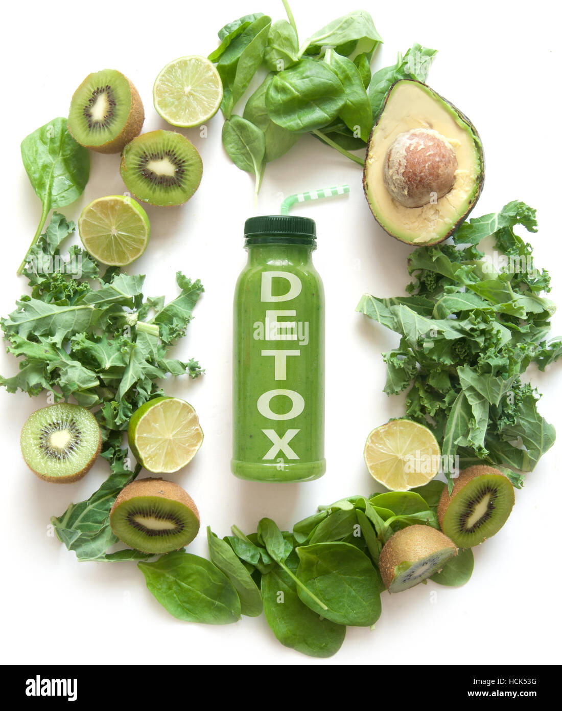 Imbottigliato frullato verde circondato con frutta e verdura compresi gli spinaci kale e avocado Foto Stock